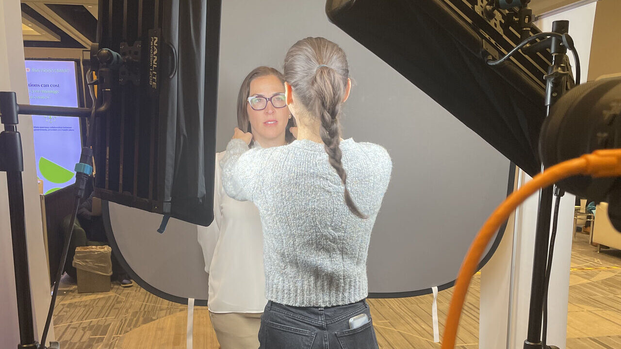 Conference headshot booth photographer coaching attendee Phoenix event